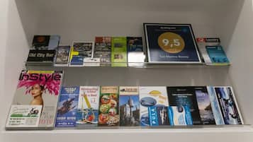 A shelf with various magazines and brochures, including 'InStyle', 'Old City Bar', and '9.5 San Martino Rooms'.