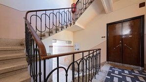Una escalera con barandilla de madera y barandales de metal negro que conduce a una plataforma.