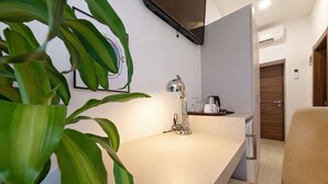 Una cocina moderna con encimera blanca, una lámpara colgante y una cafetera.