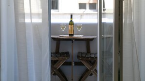 A balcony with a table, two wine glasses, and a bottle of wine. - Preziosa (Pula)