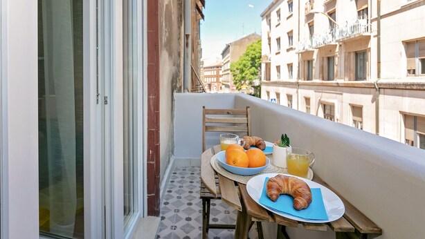 A balcony with a table set for breakfast, including croissants, oranges, and juice. - Preziosa (Pula)