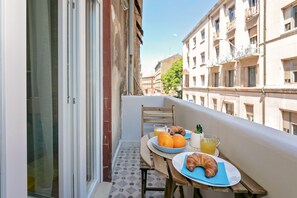 A balcony with a table set for breakfast, including croissants, oranges, and juice. - Preziosa (Pula)