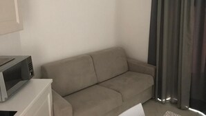 A living room with a beige sofa, a flat-screen TV, and a lamp. - THREE-ROOM APARTMENT WITH SOLARIUM AND POOL (Viddalba)