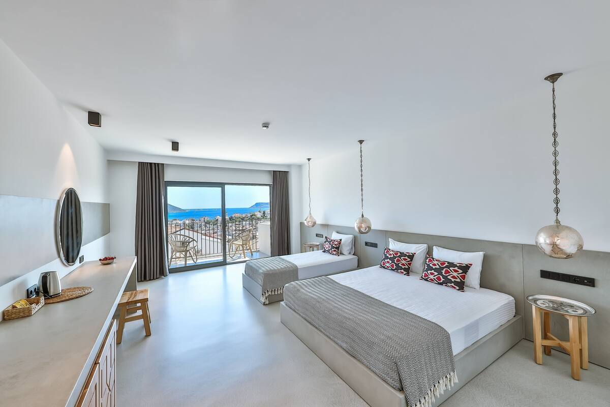 Habitación de hotel moderna con una cama grande, un escritorio pequeño y vistas a la ciudad.