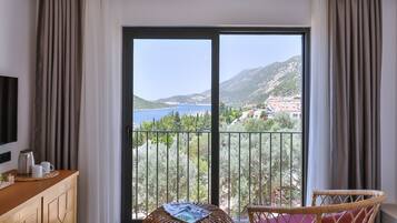 A modern room with a large sliding glass door leading to a balcony with a scenic view.