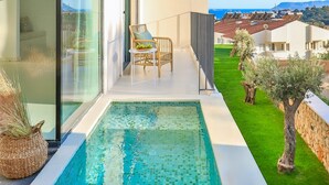 A modern outdoor pool area with a glass balustrade, a dining set, and a view of the surrounding neighborhood. - Carruba Boutique Hotel (Kas)