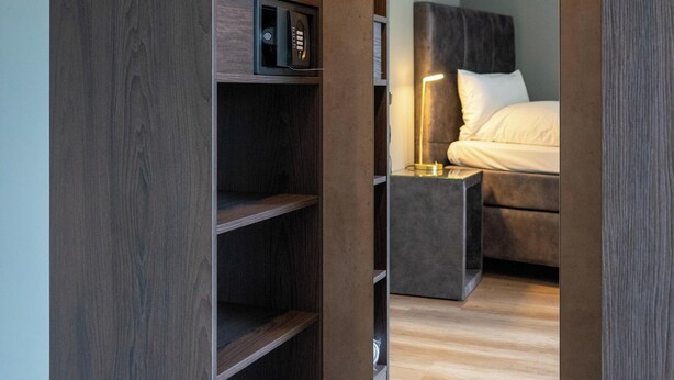 Un dormitorio moderno con armario empotrado, mesita de noche y lámpara.