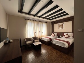 Une chambre d’hôtel avec deux lits, un bureau, une chaise et une grande fenêtre avec des rideaux.