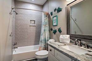 Une salle de bain avec une baignoire, des toilettes et un lavabo.