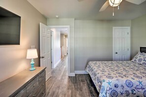 Une chambre à coucher avec un lit, une commode et un téléviseur fixé au mur.
