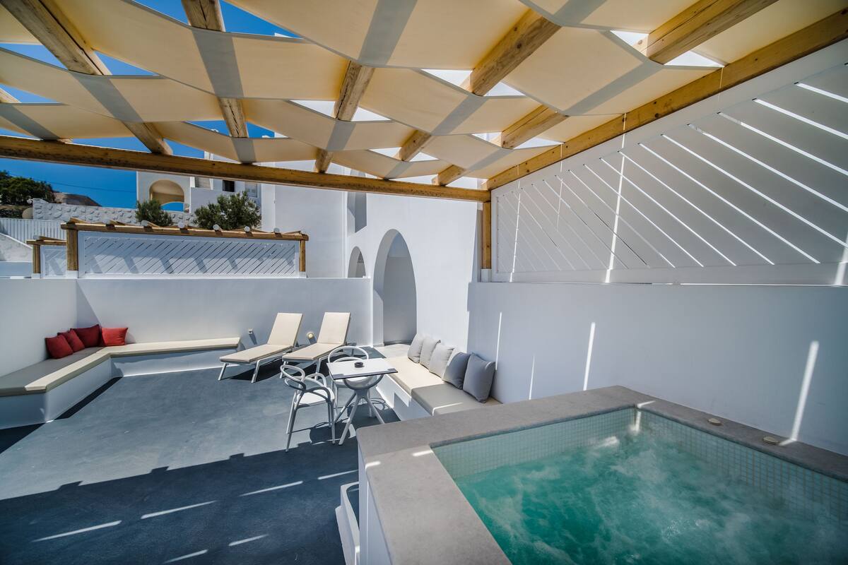 A modern outdoor pool area with a seating area, a table, and a pool.