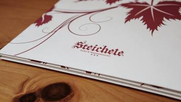 A brochure with the text "Steirchele Hotel & Weinrestaurant" and decorative leaf designs.