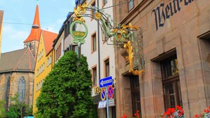 Un edificio con un letrero que dice "Wein-U" y una señal de tráfico que indica "Einbahnstrasse".