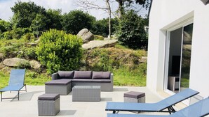 A patio with a sectional sofa, two lounge chairs, and a small table. - House 8 persons Tréboul (Douarnenez)