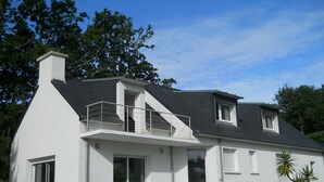 A modern two-story house with a balcony, large windows, and a sloped roof. - House 8 persons Tréboul (Douarnenez)