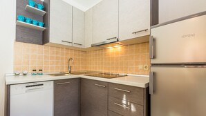 Una cucina moderna con lavastoviglie, frigorifero in acciaio inossidabile e pensili in legno.