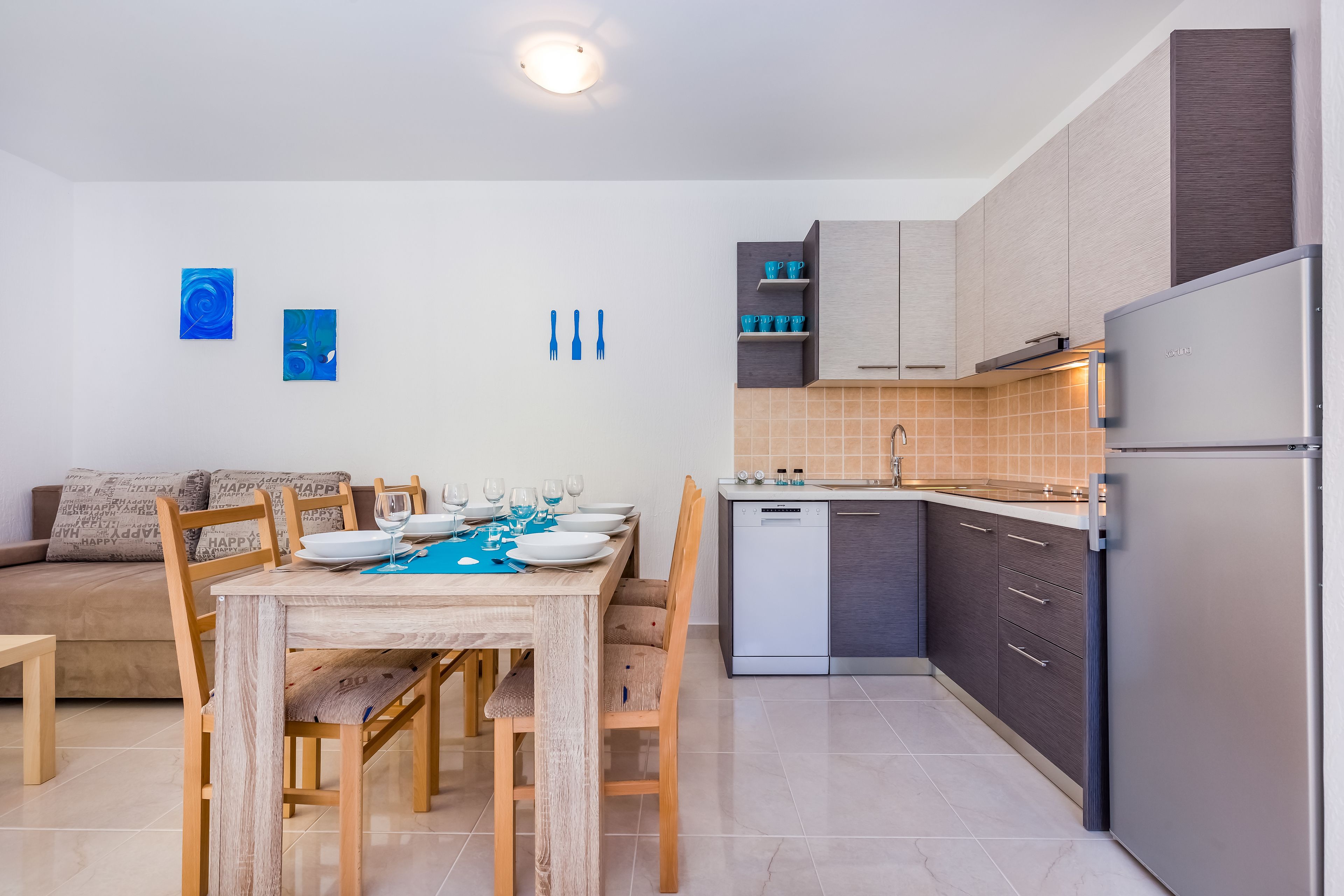 Eine moderne Küche mit Essbereich, Holzmöbeln und einem eingebauten Geschirrspüler.