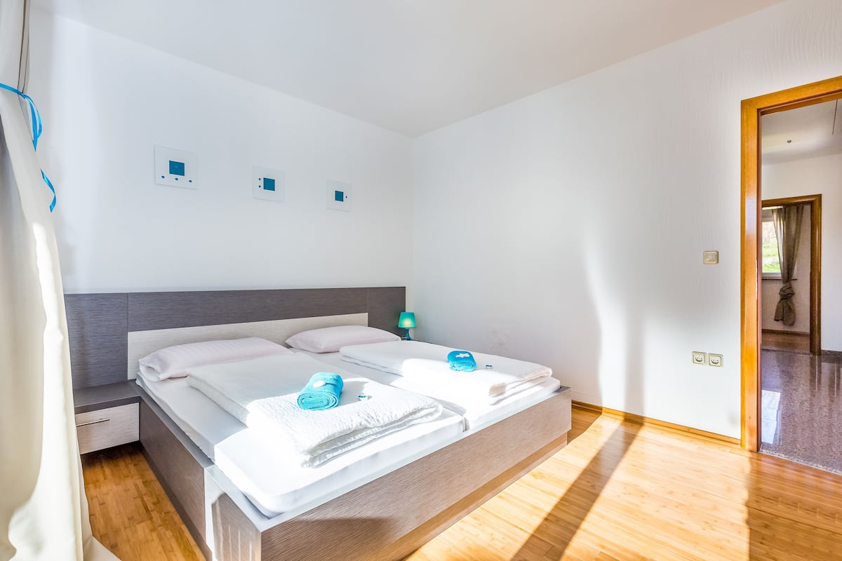 Ett modernt hotellrum med en stor säng, ett sängbord och ett litet bord.