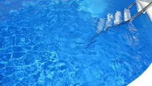 Una piscina con acqua cristallina e una scala per entrarvi.