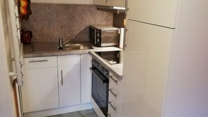 A compact kitchen with white cabinets, a microwave, a toaster, and a sink. - Your apartment directly on the Gantikow lake (Gantikow)