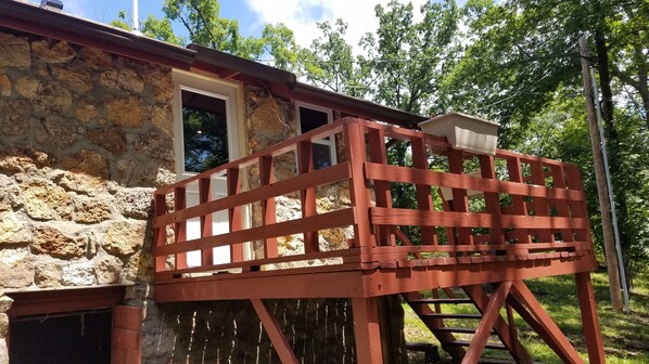 A stone building with a wooden deck and a window.