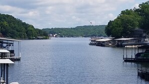 A calm lake with docked boats and a row of buildings along the shore.