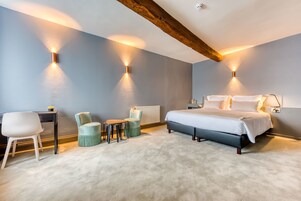 Un dormitorio moderno con una cama grande, un escritorio y dos sillas.