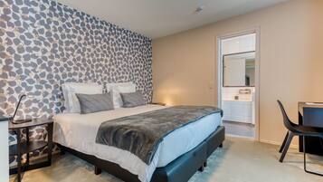 A modern bedroom with a bed, bedside table, and a chair.