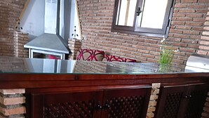 Una cocina con pared de ladrillo, ventana y encimera.