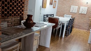 Un comedor con pared de ladrillo, una mesa blanca y sillas.