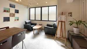 Een moderne kantoorruimte met een houten plafond, een groot raam en een whiteboard aan de muur.