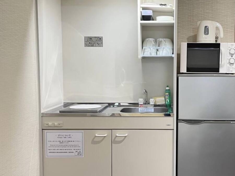 A compact kitchenette with a sink, a microwave, and a refrigerator.