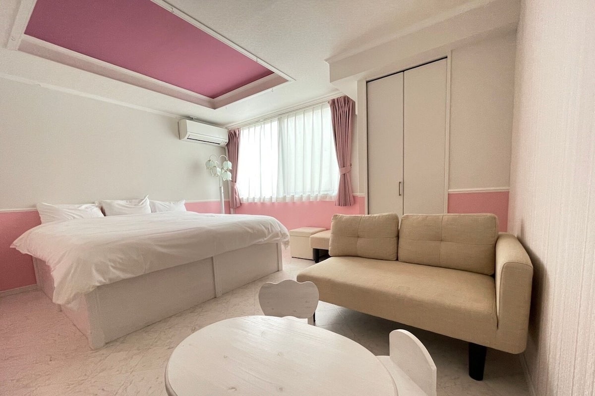 Une chambre à coucher comprenant un lit, un canapé, une petite table et une armoire.