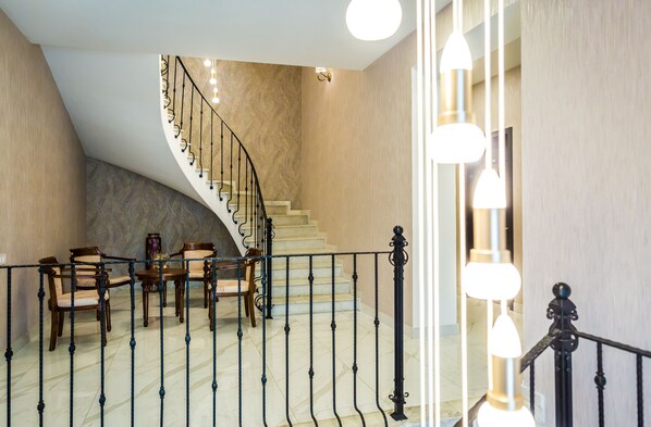 Una gran escalera de diseño curvo que conduce a un rellano con mobiliario de madera.