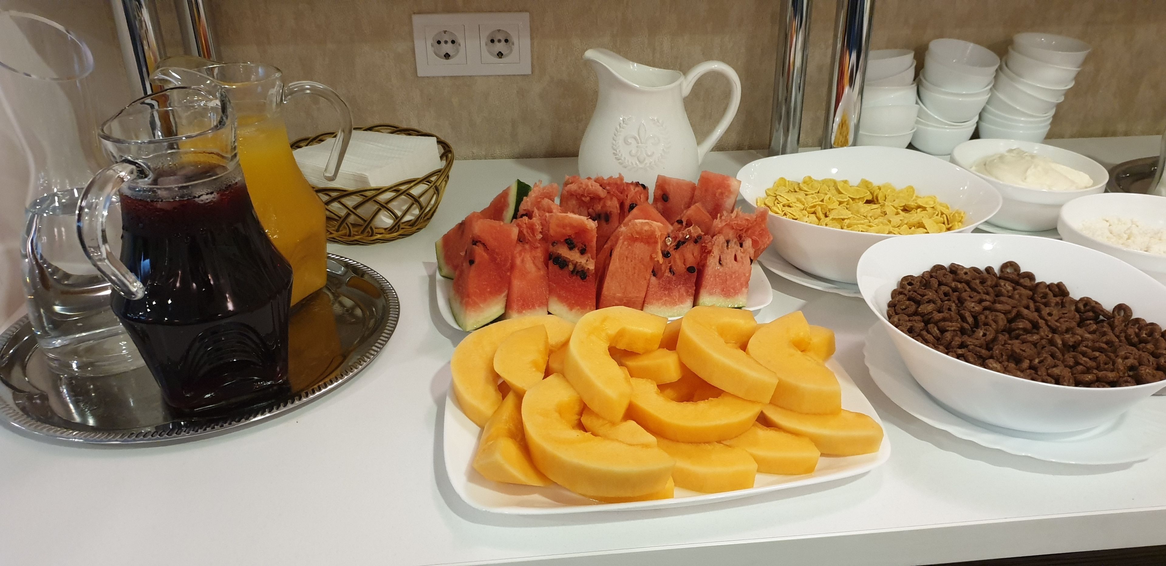 A breakfast buffet with various food items and beverages.