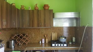 A kitchen with wooden cabinets, a granite countertop, a gas stove, and a stainless steel range hood. - beautiful sea garden (batumi)