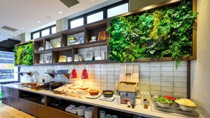 Un espace buffet proposant une variété de plats, un mur végétal et un pare-feu en carreaux.