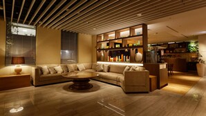 Un salon moderne avec un canapé d’angle, une table basse et un plafond en bois.