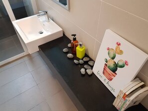 Sink, mirror, and artwork adorn this bathroom.