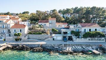 A coastal town with stone buildings, clear turquoise waters, and a rocky shoreline.