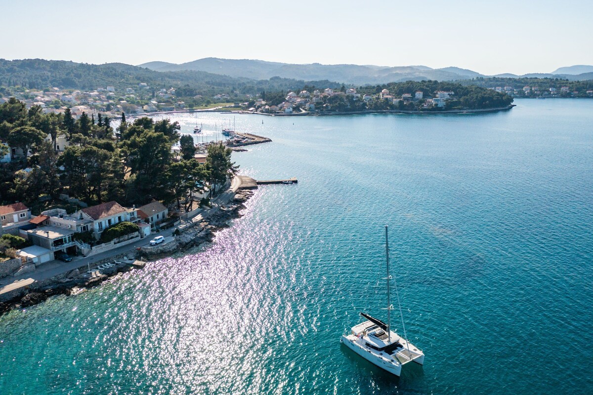 A coastal town with a marina, boats, and houses along the waterfront.