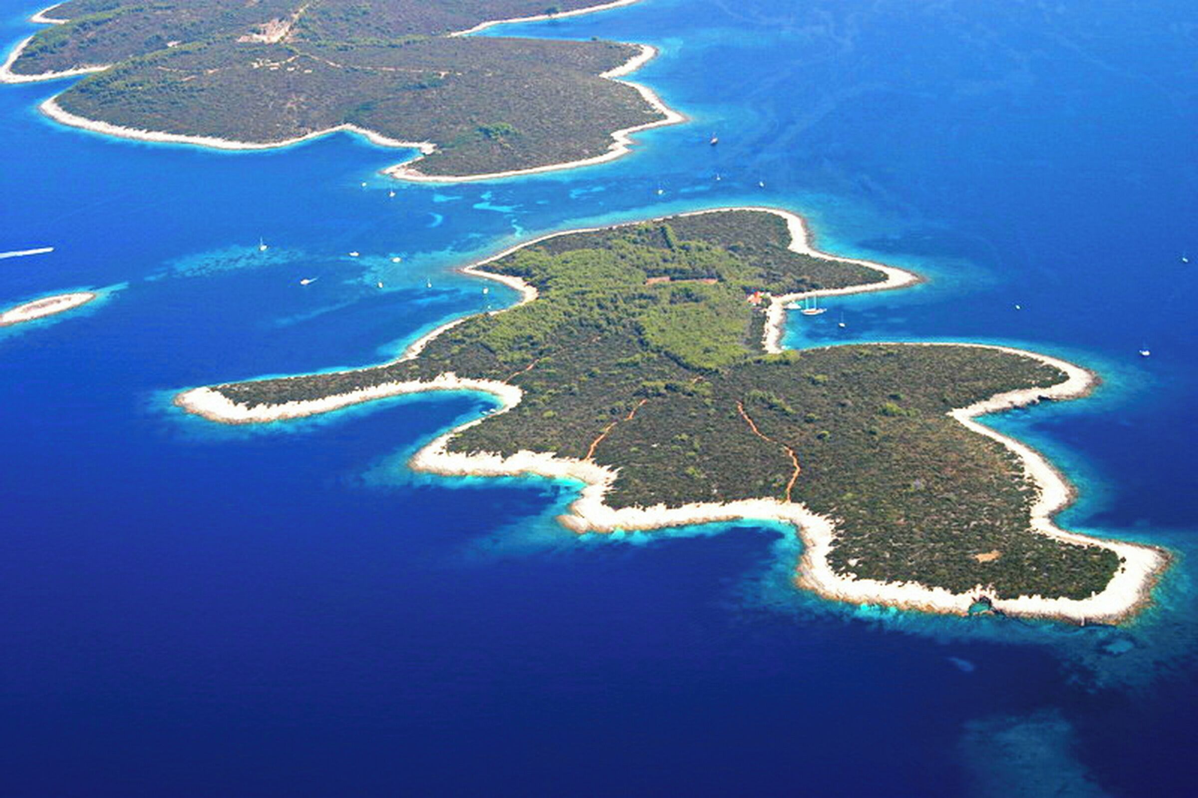 An aerial view of a chain of islands with clear blue waters and white sandy beaches.