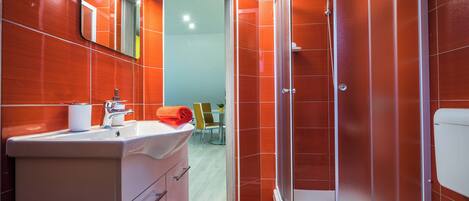 Une salle de bain moderne équipée d’une douche, de toilettes et d’un lavabo.