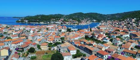 A coastal town with tightly packed buildings, a marina, and a prominent church tower.