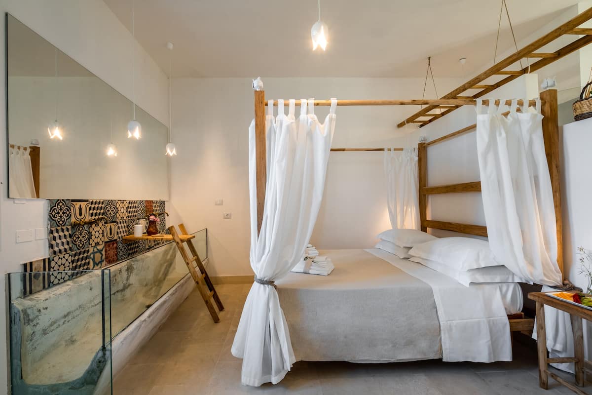 Ein modernes Schlafzimmer mit einem großen Bett, einem Holz-Kopfteil und einer Glastrennwand.