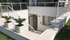 A modern building with a balcony, white railings, and two potted plants. - B&B da Patty (Affi)