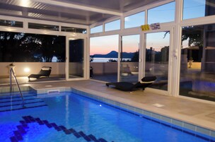 Una piscina techada, sillones reclinables de piscina