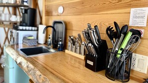 A kitchen counter with a sink, a coffee maker, and a knife block. - Yurt Overlook #10 with AC and Private Bath 2 Kings (Orderville)