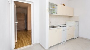 Una cocina con armarios blancos, una estufa y un lavabo.
