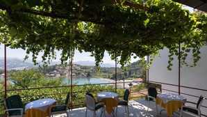 Una terraza con mesa y sillas, con vistas a un paisaje con un lago y montañas.